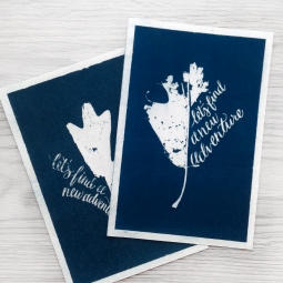 - AMY ROCHELLE PRESS - These prints were created by gathering Fall leaves with missing sections, and hand lettering "let's find a new adventure" into the missing shape of the leaf. The leaves and illustration were then exposed in a darkroom to handmade cyanotype paper creating this deep blue, direct image.