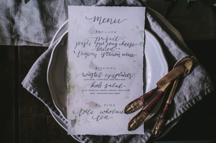 Detailed shot of calligraphy menus showing deckled edges, pearl accents, and soft gray and emerald ink. Each course was hand lettered onto print paper | Photo by Eva Kosmas Flores | AMY ROCHELLE PRESS